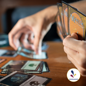 Player holding Magic the Gathering cards and picking from decks on table