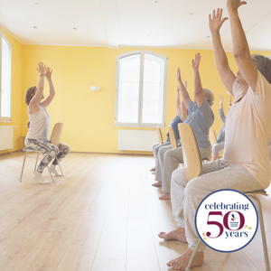 People sitting in chairs practicing yoga