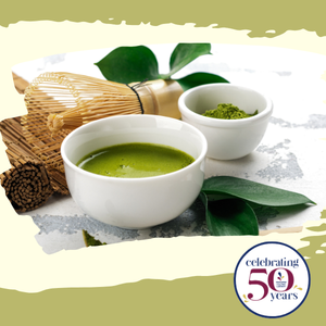 Cup of matcha tea, small bowl of matcha powder and whisk